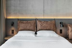 a bedroom with a large bed with two pillows at Moxy Aarhus in Aarhus +5 photos