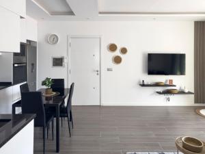 a kitchen and dining room with a table and a tv at Modern 2-bdr apt with rooftop pool - LCGR in Praia