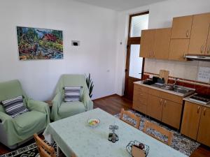 a living room with a table and chairs and a kitchen at Little Bear Busteni - Închiriere integrală, cameră de jocuri, parcare privată, potrivită și pentru munca la distanță in Buşteni