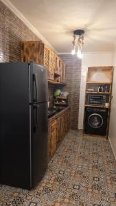 a kitchen with a black refrigerator and a microwave at Maison marhaba2 app 3 in Agadir