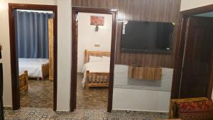 a room with a tv and a bedroom with a bed at Maison marhaba2 app 3 in Agadir