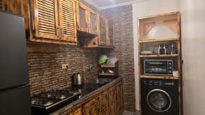 a small kitchen with a stove and a microwave at Maison marhaba2 app 3 in Agadir +5 photos