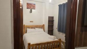 a bedroom with a bed and a blue curtain at Maison marhaba2 app 3 in Agadir