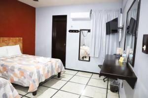 a bedroom with a bed and a table and a mirror at Hotel Murallas 231, CENTRO HISTORICO in Campeche