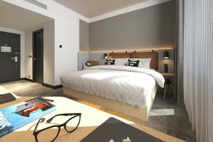 a bedroom with a large white bed and a table at Moxy Belgrade Skadarlija in Belgrade