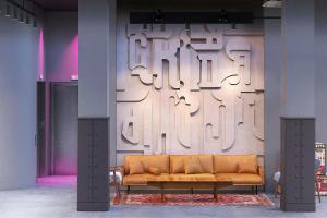 a couch in a room with a wall with writing on it at Moxy Belgrade Skadarlija in Belgrade