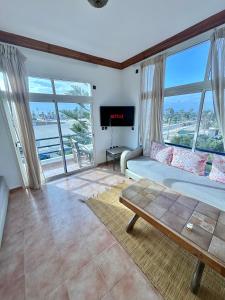 a living room with a couch and large windows at oualidia surfhouse in Oualidia