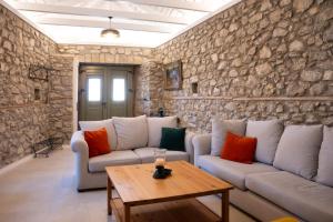 a living room with two couches and a table at Achyronas 1840 Stone House in Graviá