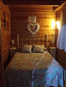 a bedroom with a bed with a heart on the wall at El Rincón de María. in Riópar +29 photos