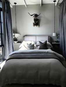 a bedroom with a bed with a bull head on the wall at Frogs Pond in Red Hill