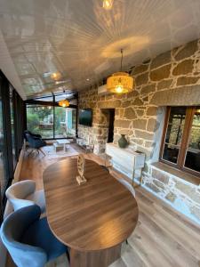 a wooden table in a room with a stone wall at Maison de charme en pierre in Porto Ota
