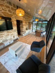 a living room with a stone wall and a table and chairs at Maison de charme en pierre in Porto Ota