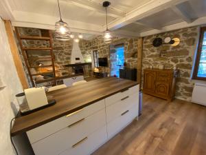 a kitchen with a counter with white cabinets at Maison de charme en pierre in Porto Ota