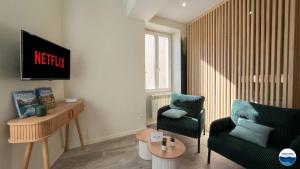 a living room with a couch and a chair at La Suite Vegetale Studio Prestige Hyper Centre in Mâcon