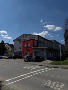 a red and white building on the corner of a street at Apartmán pod Čebraťom in Ružomberok