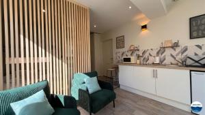 a living room with a couch and a chair at La Suite Vegetale Studio Prestige Hyper Centre in Mâcon