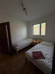 a bedroom with two beds and a window at Apartmán pod Čebraťom in Ružomberok +3 photos