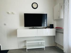 a flat screen tv sitting on a white wall at Maisonnette du bonheur in Courseulles-sur-Mer
