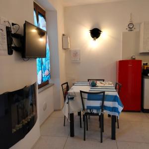 a dining room with a table with chairs and a tv at Appartamento Giuse Mari in Suvereto