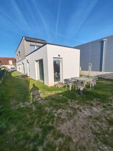a building with a table and benches in the grass at Basel Access Apart - Habsheim in Habsheim