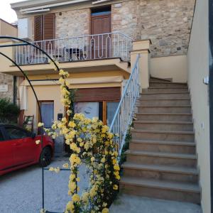 a stairway leading up to a house with yellow flowers at Appartamento Giuse Mari in Suvereto