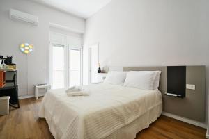 a white bedroom with a large bed with white sheets at Casa Lomè - Dimora Vacanze in Conversano