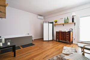 a living room with white walls and wooden floors at Casa Lomè - Dimora Vacanze in Conversano
