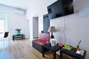 a living room with a couch and a tv on a wall at Casa Lomè - Dimora Vacanze in Conversano