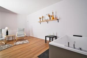 a white living room with a tub and a chair at Casa Lomè - Dimora Vacanze in Conversano