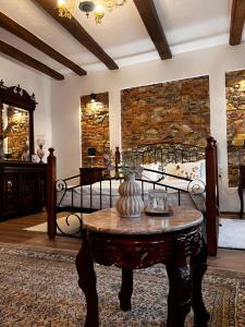 a living room with a table and a stone wall at Casa Ceauș in Baia-Sprie