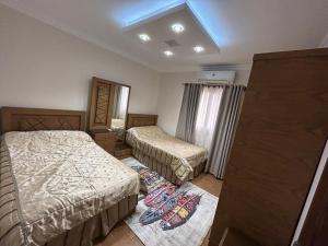 a hotel room with two beds and a window at Decent brand new flat with garden view in New cairo