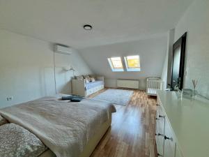 a bedroom with a large bed and a dresser and windows at Apartmán Gabi in Lučenec