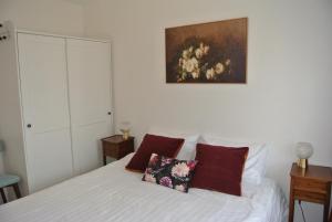 a bedroom with a white bed with two pillows at Le Jardin de Madison in Cessy