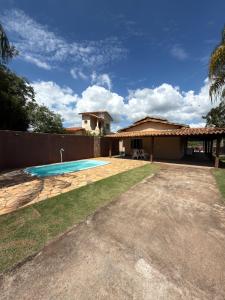 a house with a swimming pool in a yard at Rancho Renato Chaveiro in Capitólio