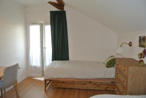 a bedroom with a bed and a dresser and a window at Le Jardin de Madison in Cessy +19 photos