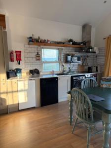 a kitchen with white appliances and a table with chairs at Beautiful Seaside Cottage Wicklow town in Wicklow