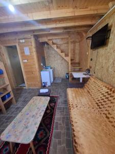 a room with a couch and a table and a tv at Camp Volujak in Gacko