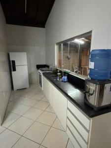a kitchen with a sink and a refrigerator at Rancho Renato Chaveiro in Capitólio