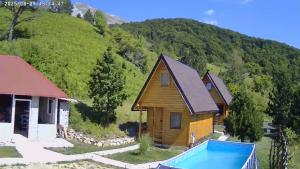 a house with a swimming pool in front of a mountain at Camp Volujak in Gacko