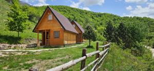 a wooden cabin on a hill with a fence at Camp Volujak in Gacko