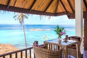 a table and chairs on a balcony with the ocean at Beyond The Blue Horizon Boutique Bungalows in Haad Chao Phao +68 photos