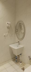 a white bathroom with a sink and a mirror at شقة واحة رتيل الفندقية in Al-ʿUla