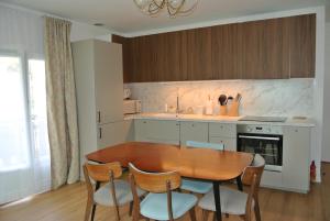 a kitchen with a wooden dining table and chairs at Le Jardin de Madison in Cessy