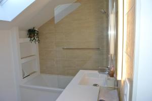 a bathroom with a sink and a bath tub at Le Jardin de Madison in Cessy