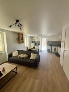 a living room with a couch and a kitchen at Maison de village in Collanges
