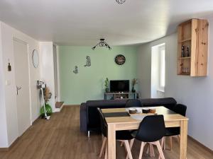 a living room with a table and a couch at Maison de village in Collanges