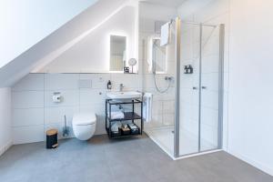 a white bathroom with a sink and a shower at Tonirooms 3-Zimmer Buntspecht in Straubing +3 photos