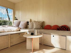 a living room with a bed and a table at Tiny House 2 mit Garten in der Lüneburger Heide in Soltau