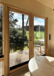 a room with a sliding glass door with a view of a deck at Tiny House 2 mit Garten in der Lüneburger Heide in Soltau +14 photos