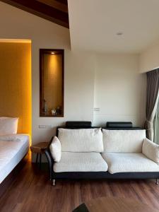 a living room with a couch and a mirror at After the Court Chiaohsi in Jiaoxi